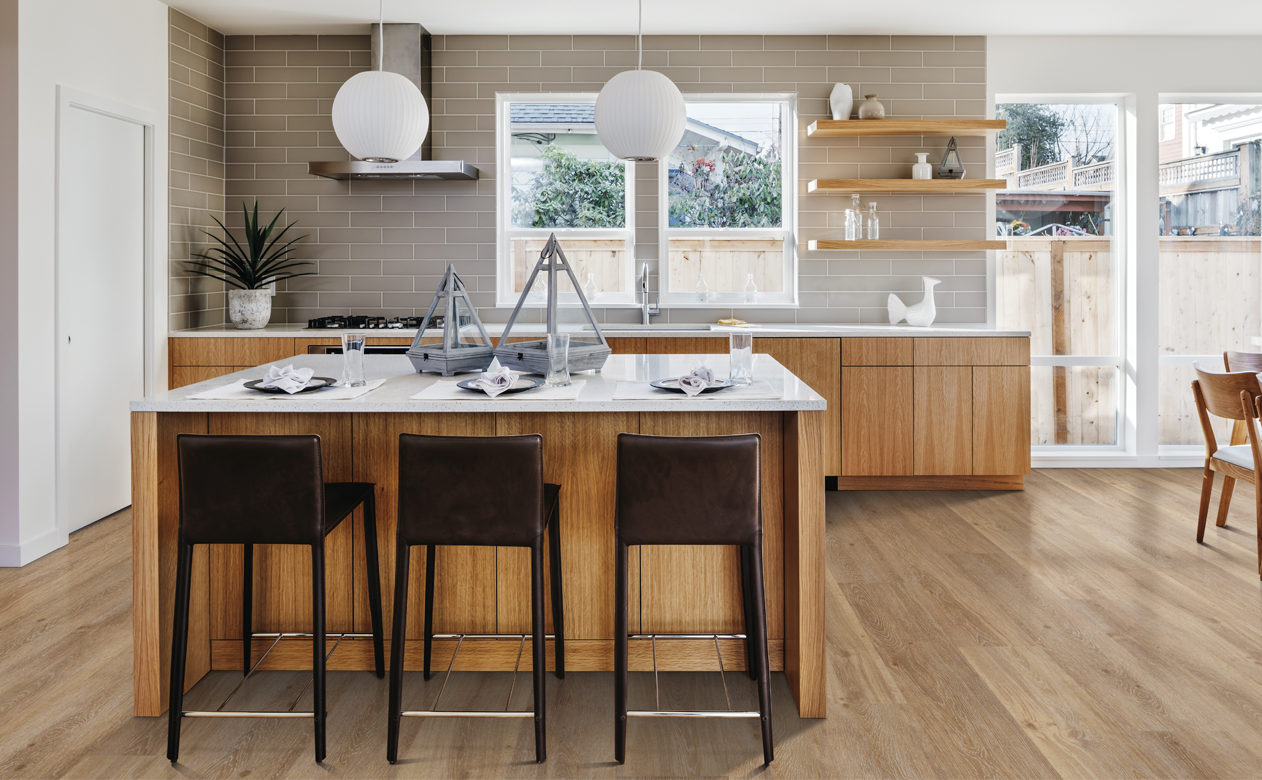  wood cabinets in modern kitchen with brown stools and white stone countertops